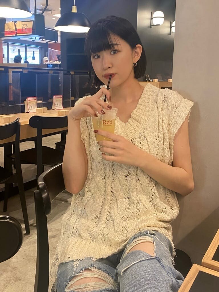 ブルー系のデニムパンツ、ベージュ系のスリッポン、ホワイト系のベストを着用したレディースの夏コーディネートの5枚目の写真