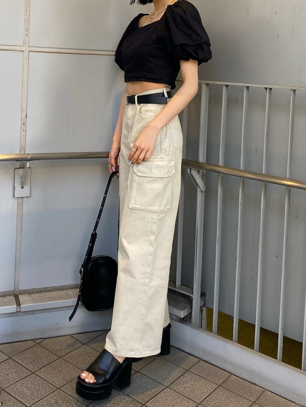 ブラック系のサンダル、ホワイト系のデニムパンツ、ブラック系のシャツ/ブラウスを着用したレディースの春コーディネートの6枚目の写真