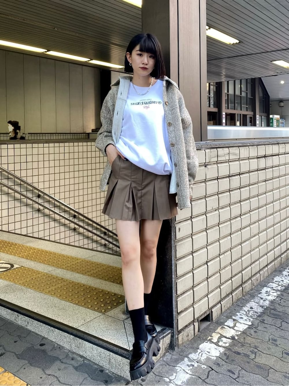 ブラック系のローファー、ブラック系のローファー、ベージュ系のスカートを着用したレディースの秋コーディネートの2枚目の写真