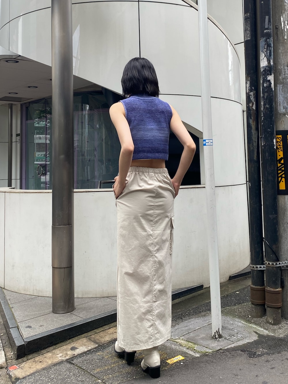 ホワイト系のブーツ、ホワイト系のスカート、ブルー系のタンクトップを着用したレディースの春コーディネートの4枚目の写真