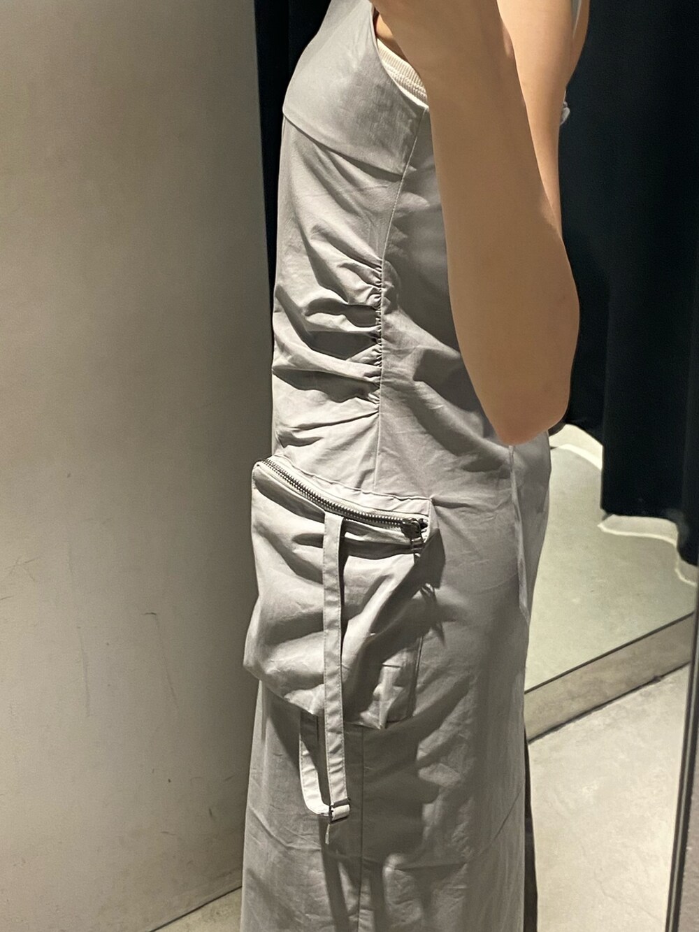 グレー系のワンピース、ブラック系のサンダル、ホワイト系のキャミソールを着用したレディースの夏コーディネートの7枚目の写真