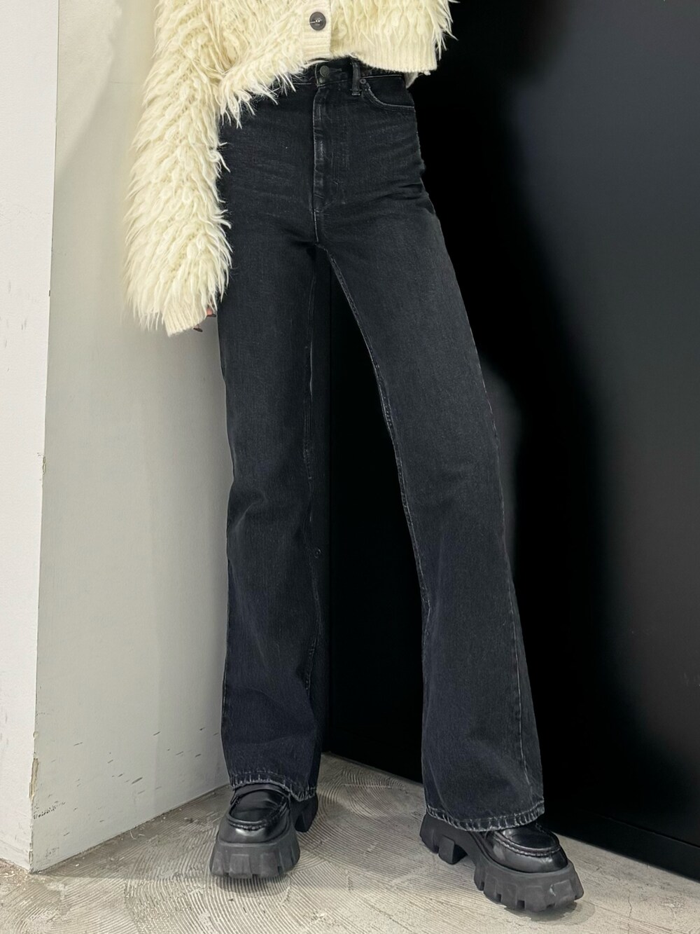 ブラック系のデニムパンツ、ホワイト系のカーディガン/ボレロを着用したレディースの秋コーディネートの5枚目の写真