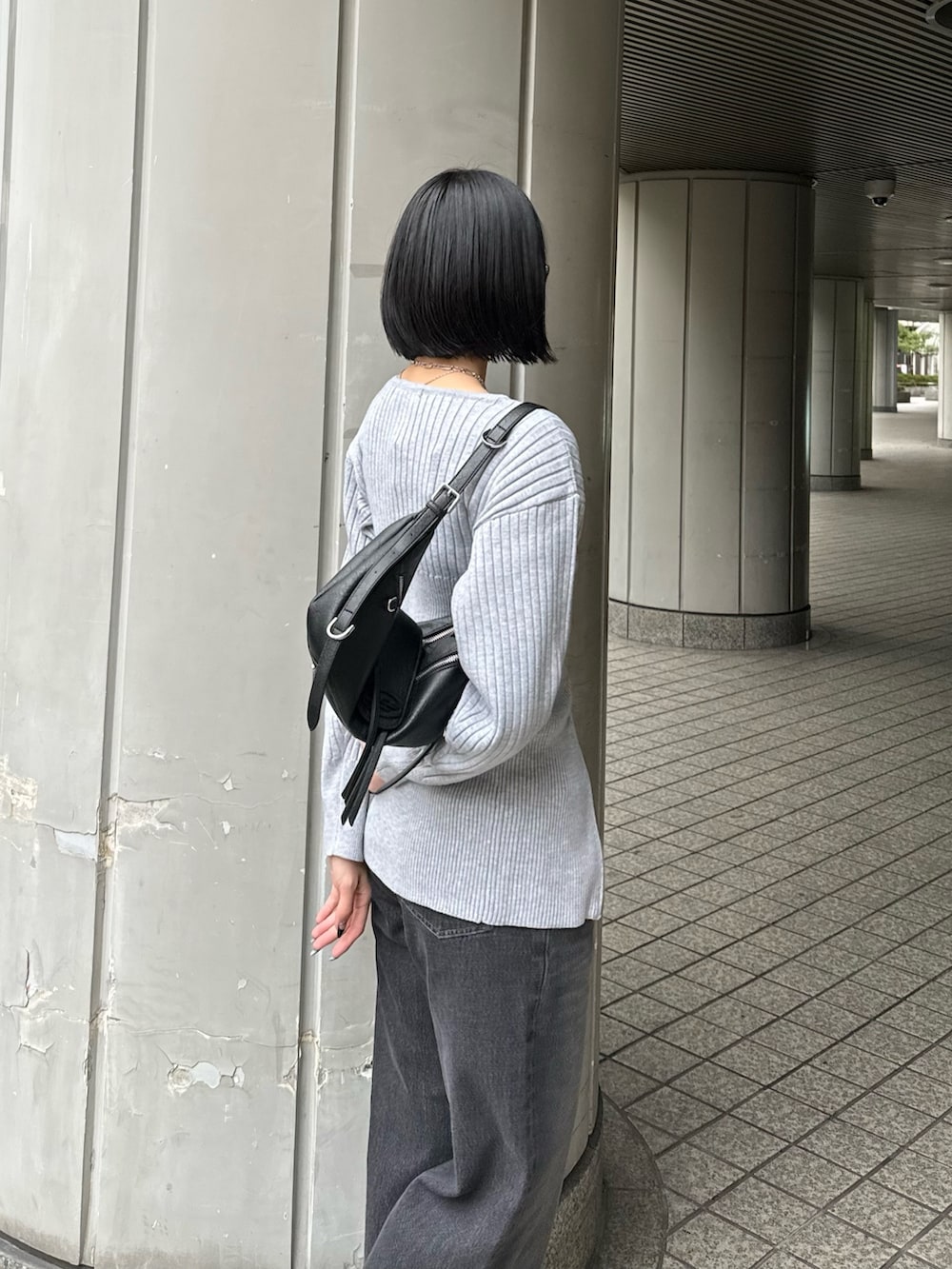 ブラック系のブーツ、ブラック系のデニムパンツ、グレー系のニット/セーターを着用したレディースの冬コーディネートの7枚目の写真