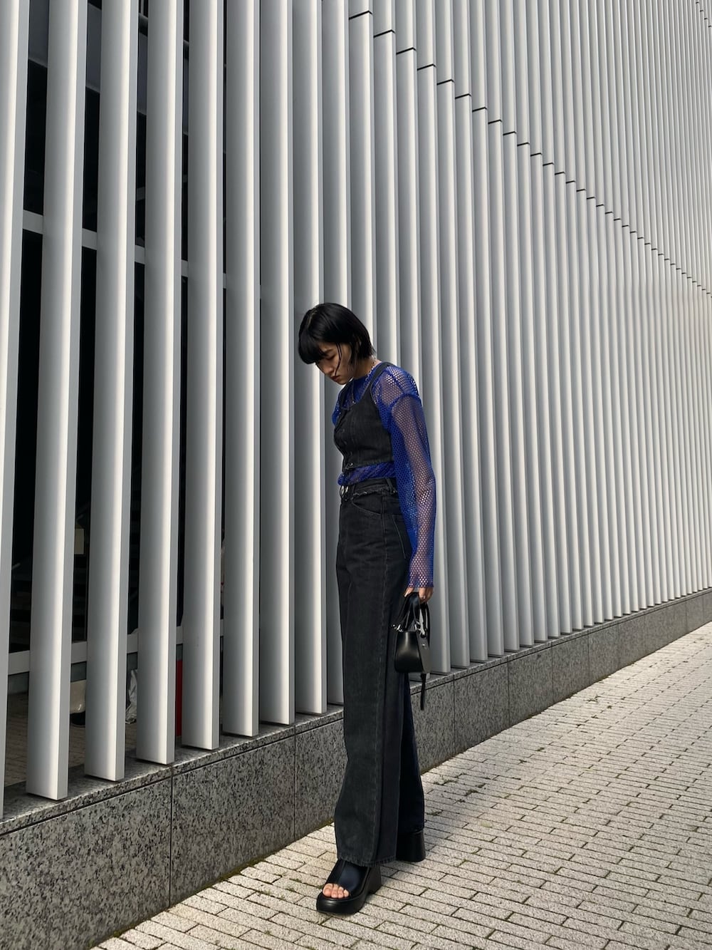 ブラック系のサンダル、ブラック系のデニムパンツ、ブラック系のその他トップスを着用したレディースの春コーディネートの6枚目の写真