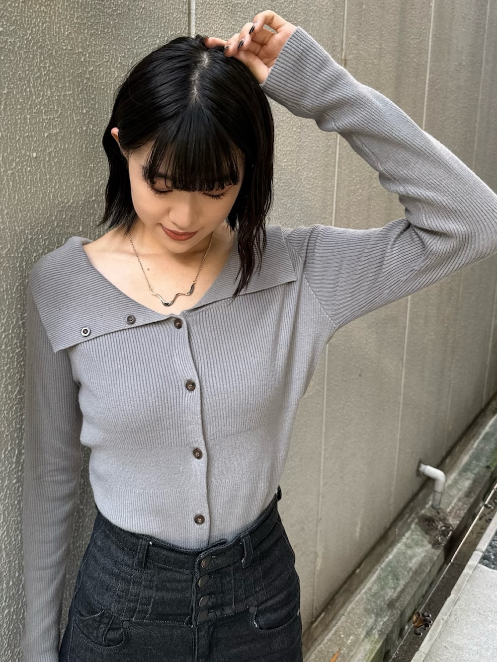 ブラック系のデニムパンツ、ブラック系のブーツ、グレー系のニット/セーターを着用したレディースの秋コーディネートの6枚目の写真