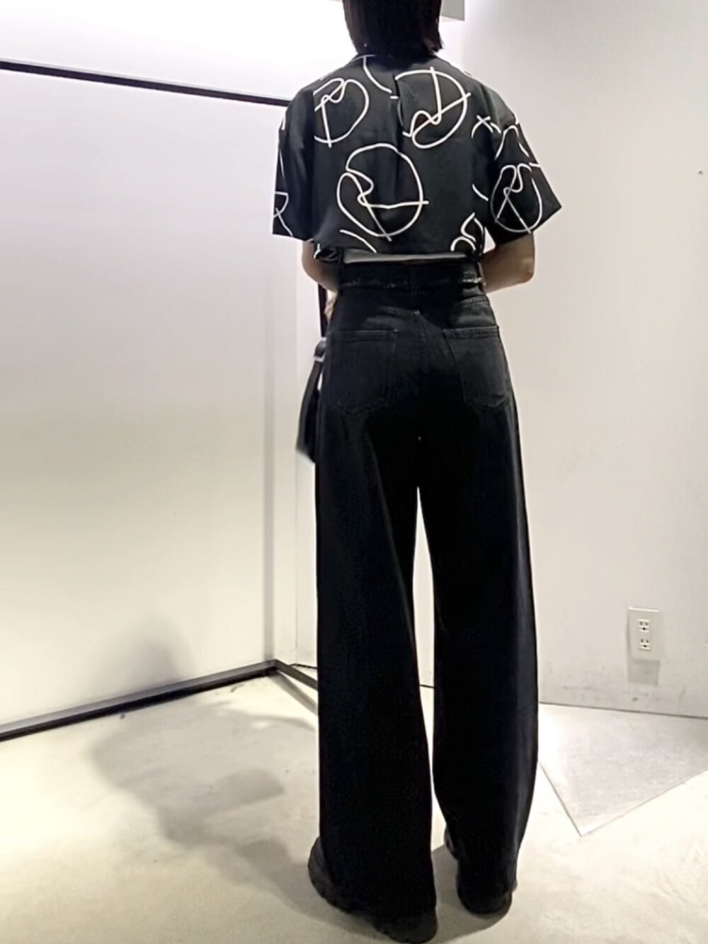 ブラック系のブーツ、ブラック系のデニムパンツ、ブラック系のショルダーバッグを着用したレディースの夏コーディネートの4枚目の写真