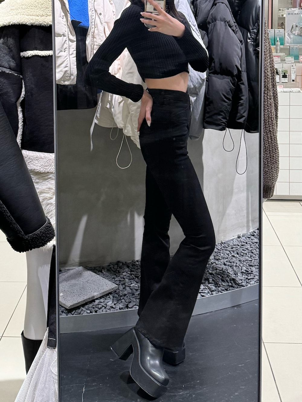 ブラック系のブーツ、ブラック系のデニムパンツ、ブラック系のニット/セーターを着用したレディースの冬コーディネートの4枚目の写真