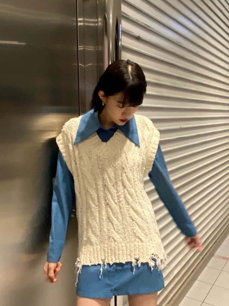 ホワイト系のベスト、ブルー系のワンピース、ブラック系のブーツを着用したレディースの夏コーディネートの6枚目の写真