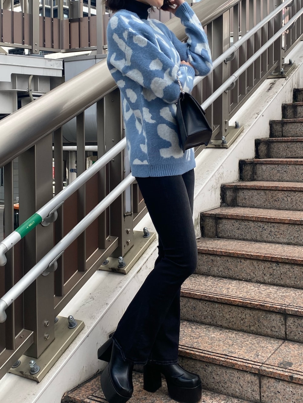 ブルー系のニット/セーター、ブラック系のハンドバッグ、ブラック系のブーツを着用したレディースの冬コーディネートの5枚目の写真