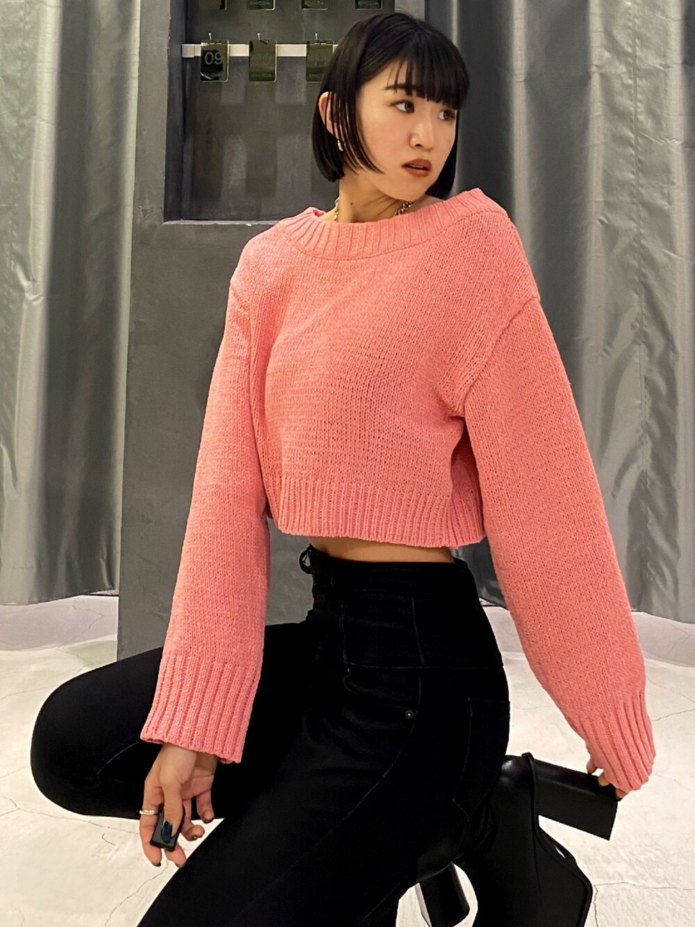 ブラック系のブーツ、ブラック系のデニムパンツ、ピンク系のニット/セーターを着用したレディースの秋コーディネートの5枚目の写真