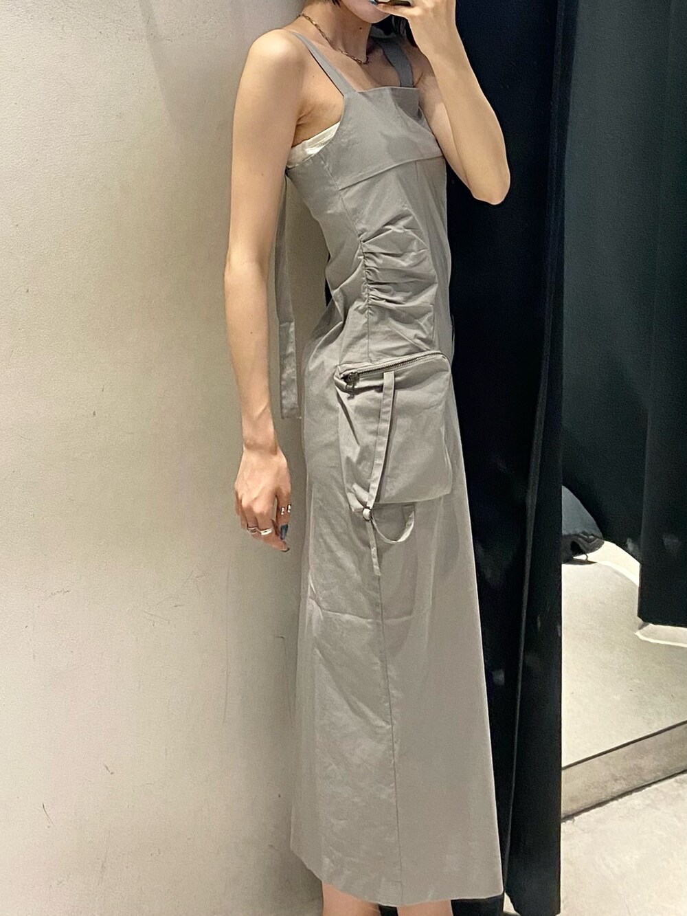 グレー系のワンピース、ブラック系のサンダル、ホワイト系のキャミソールを着用したレディースの夏コーディネートの9枚目の写真