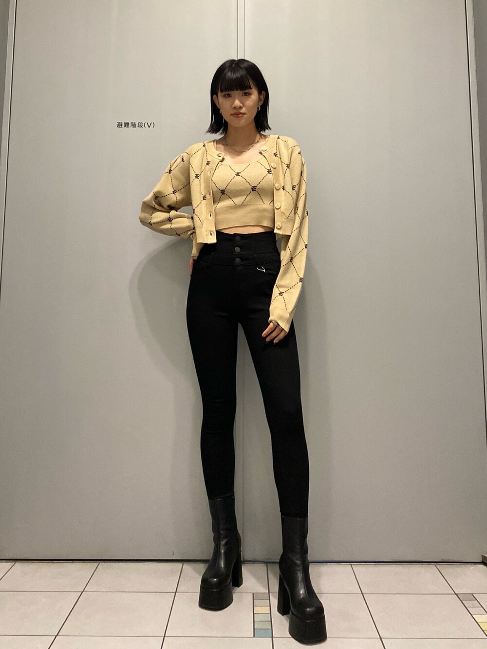 ブラック系のブーツ、ブラック系のデニムパンツ、ベージュ系のニット/セーターを着用したレディースの秋コーディネートの2枚目の写真