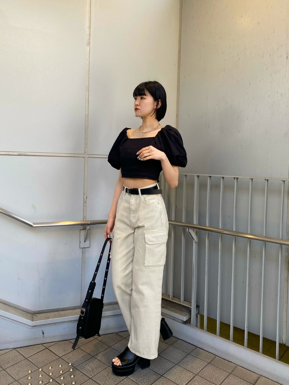 ブラック系のサンダル、ホワイト系のデニムパンツ、ブラック系のシャツ/ブラウスを着用したレディースの春コーディネートの5枚目の写真