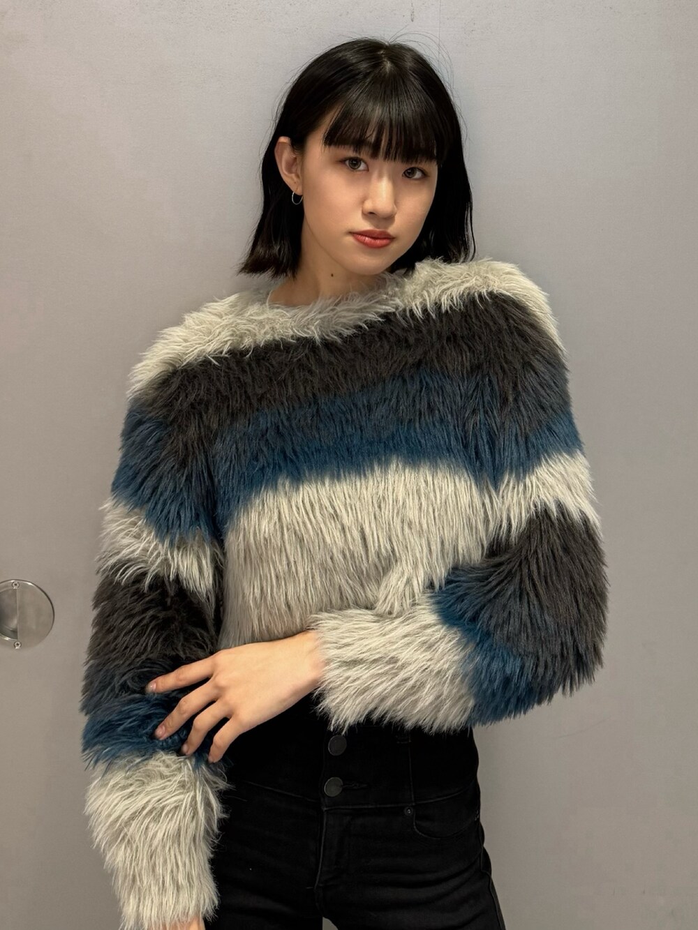 ブラック系のブーツ、ブラック系のデニムパンツ、その他のニット/セーターを着用したレディースの秋コーディネートの6枚目の写真