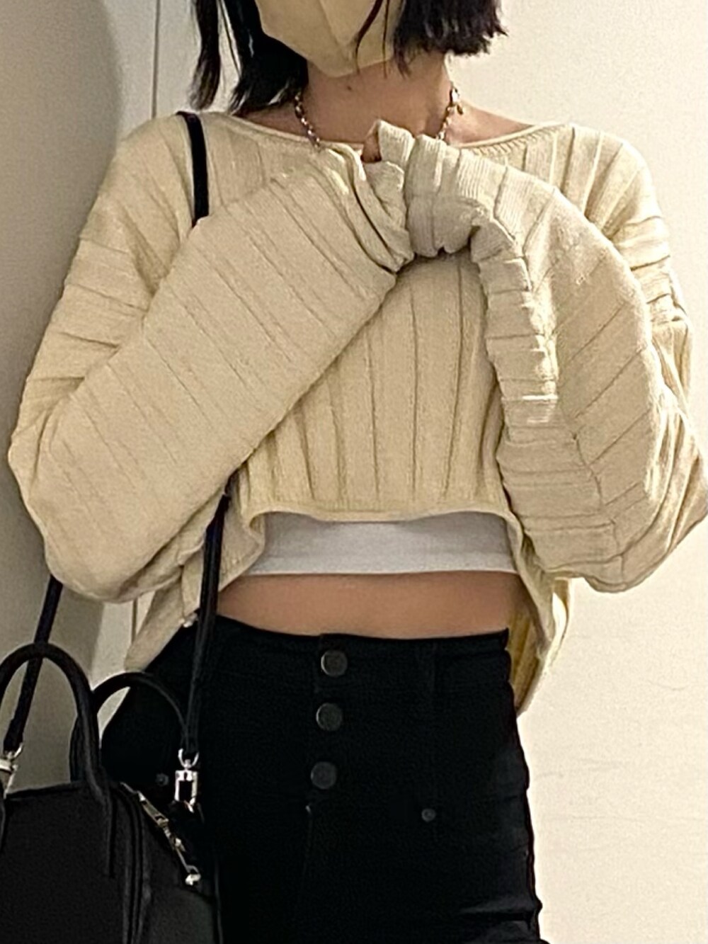 ブラック系のブーツ、ブラック系のデニムパンツ、ホワイト系のニット/セーターを着用したレディースの春コーディネートの6枚目の写真