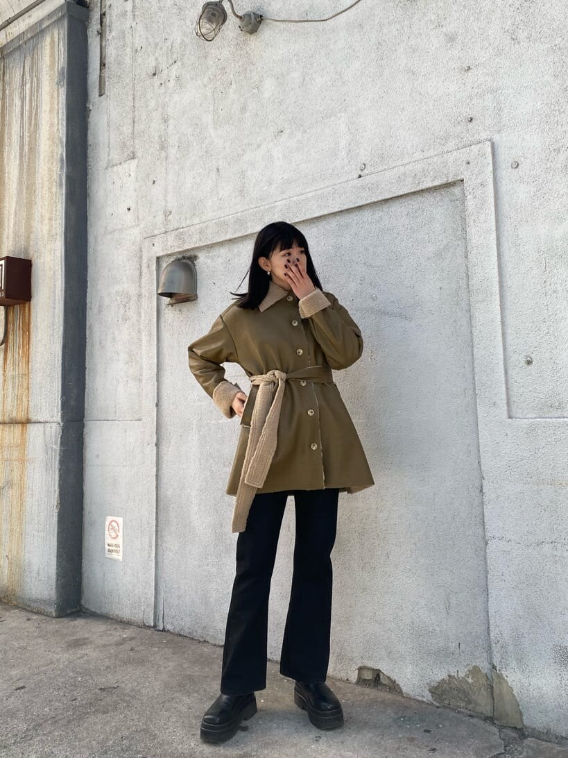 ホワイト系のニット/セーター、ホワイト系のハンドバッグ、ベージュ系のムートンコートを着用したレディースの冬コーディネートの2枚目の写真