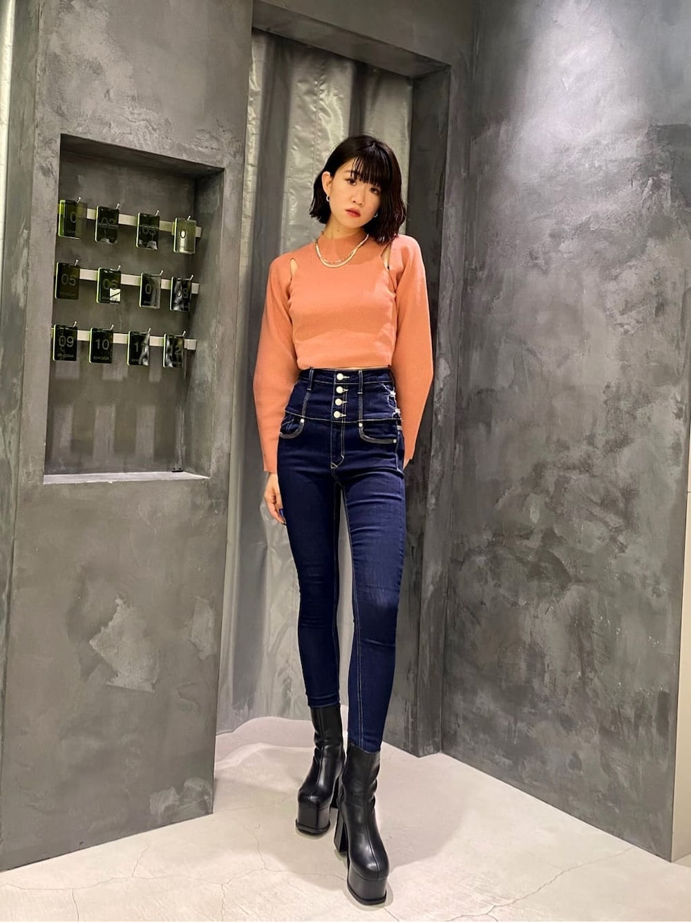 ブラック系のブーツ、ブルー系のデニムパンツ、ピンク系のニット/セーターを着用したレディースの秋コーディネートの3枚目の写真