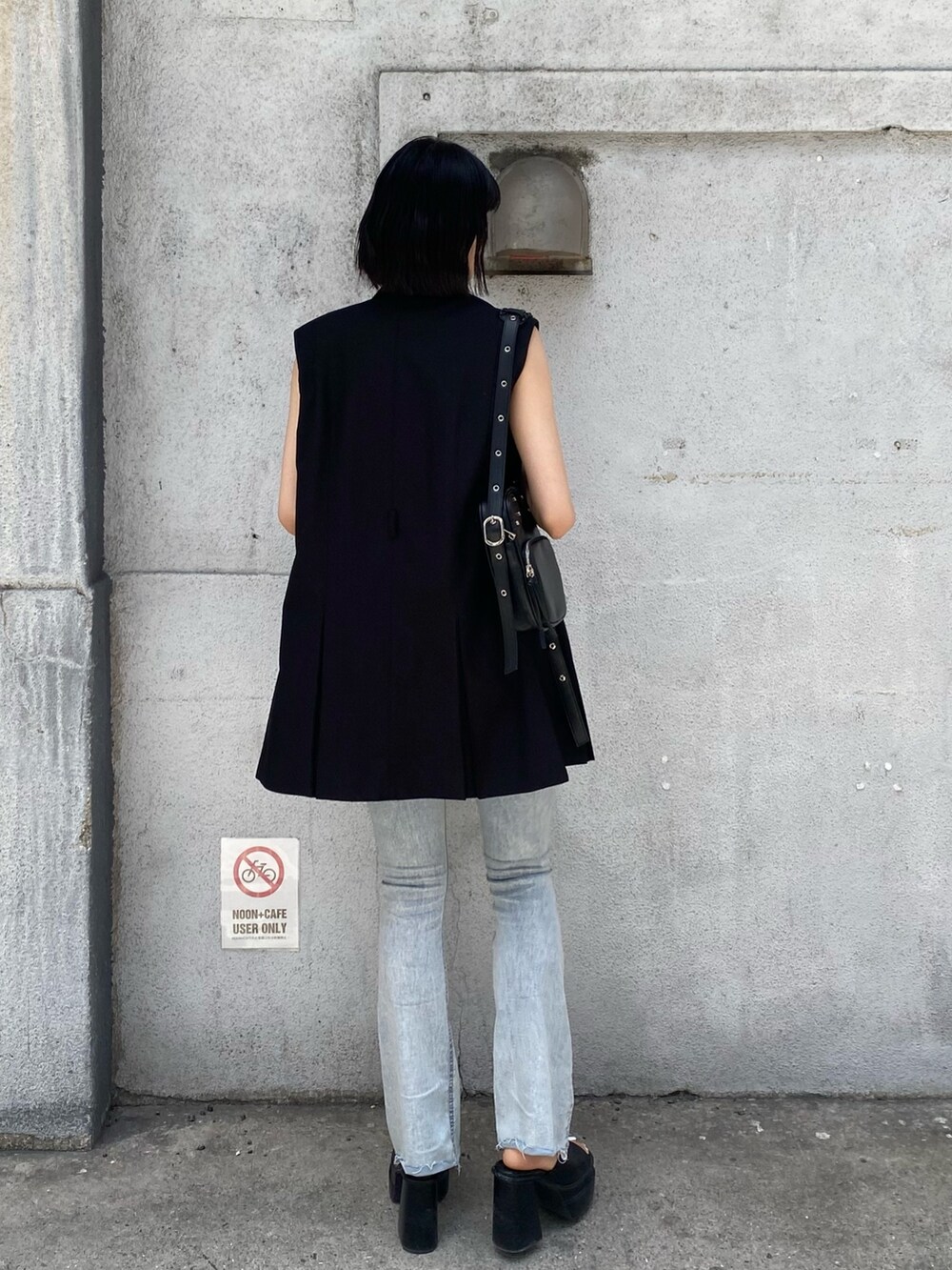 ブラック系のサンダル、ブラック系のショルダーバッグ、ブラック系のワンピースを着用したレディースの春コーディネートの3枚目の写真