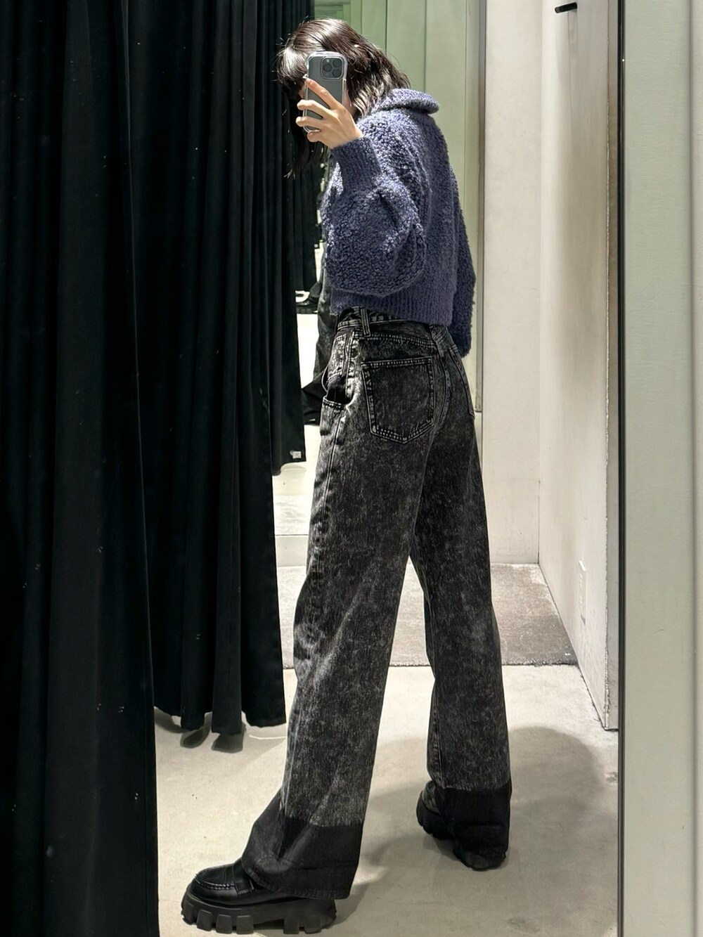 ブラック系のデニムパンツ、ブルー系のニット/セーター、ブラック系のローファーを着用したレディースの秋コーディネートの4枚目の写真