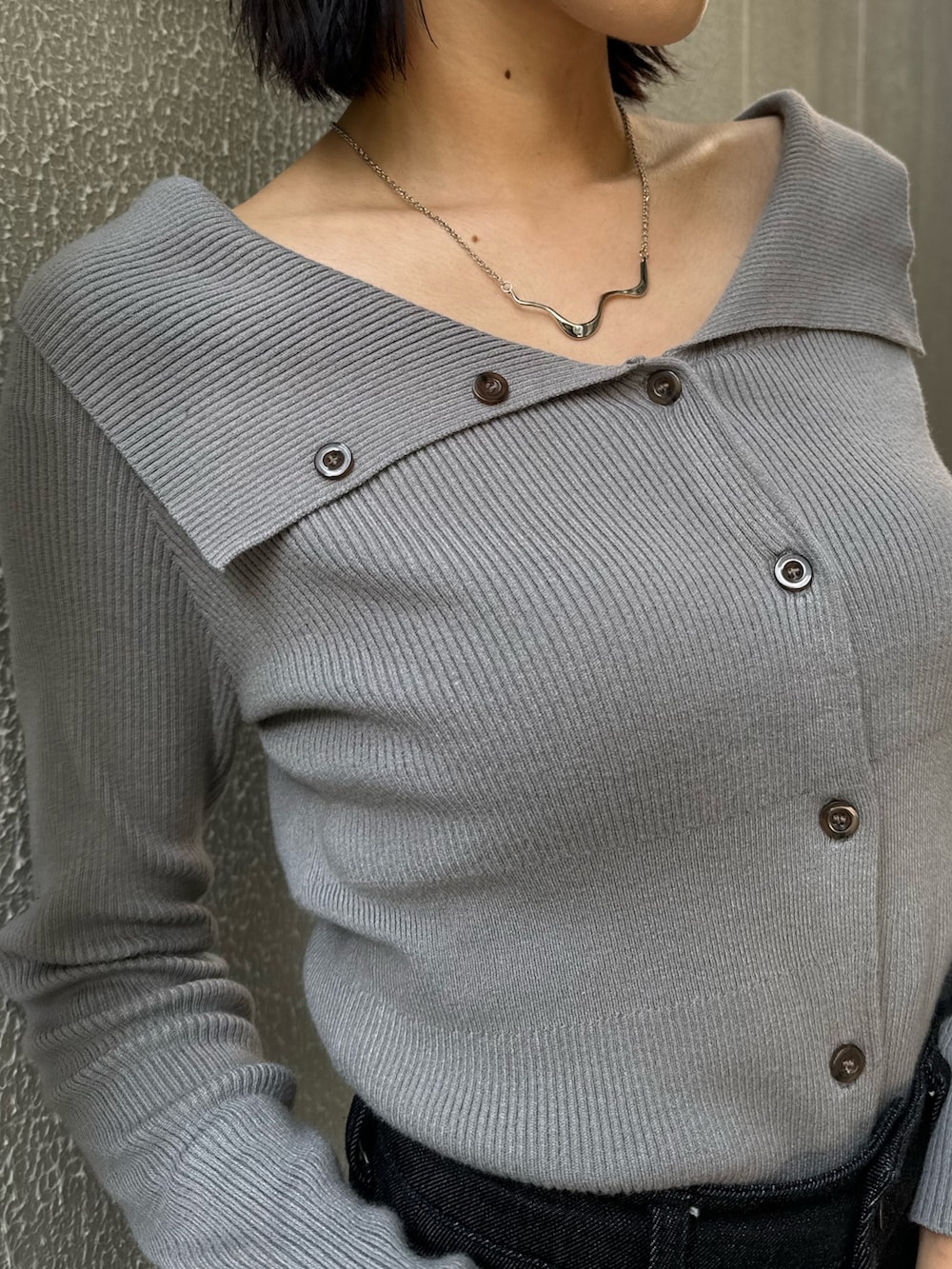 ブラック系のデニムパンツ、ブラック系のブーツ、グレー系のニット/セーターを着用したレディースの秋コーディネートの10枚目の写真