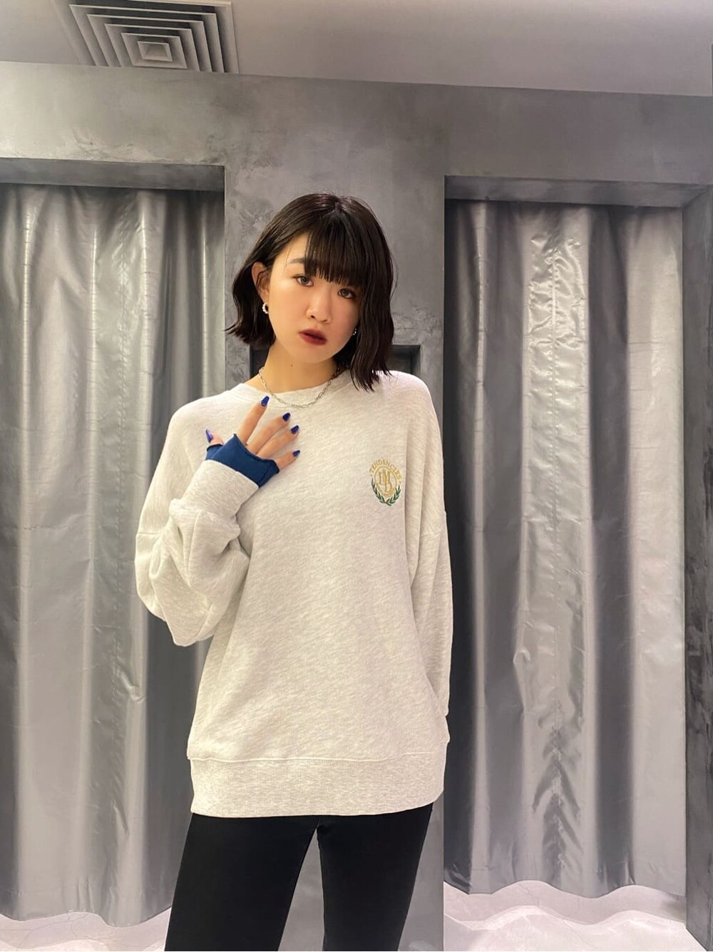 ブラック系のベスト、グレー系のスウェット、ブルー系のアームカバーを着用したレディースの秋コーディネートの5枚目の写真