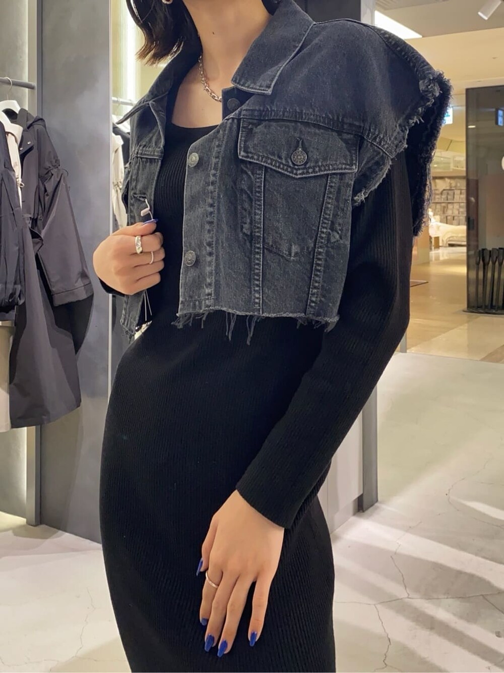 ブラック系のブーツ、ブラック系のワンピース、ブラウン系のハンドバッグを着用したレディースの秋コーディネートの4枚目の写真