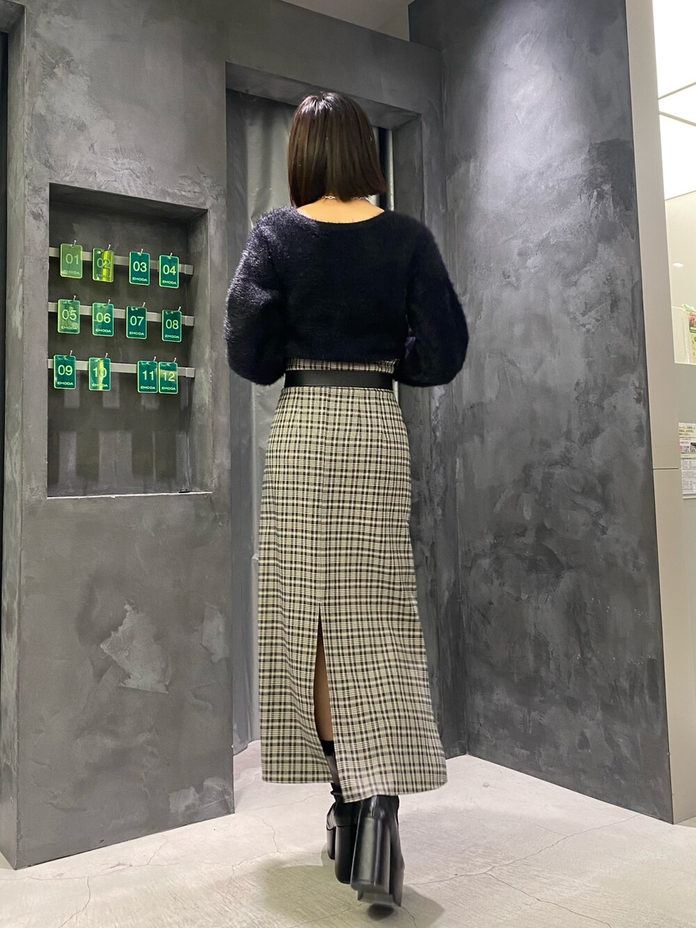 ブラック系のブーツ、ブラック系のニット/セーター、その他のスカートを着用したレディースの冬コーディネートの3枚目の写真