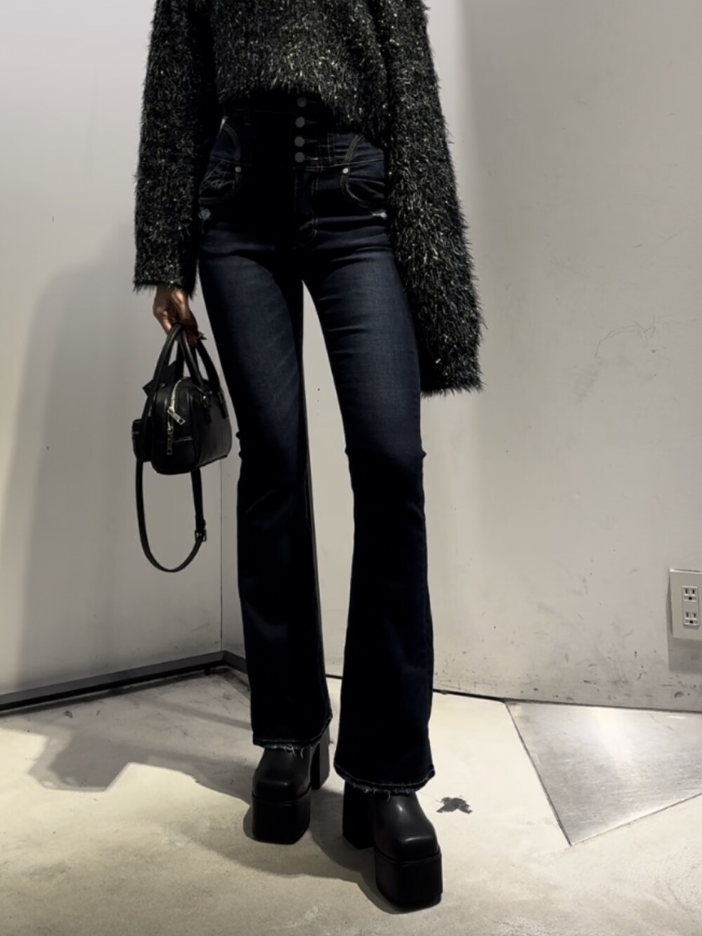 ブラック系のハンドバッグ、ブラック系のニット/セーター、ブルー系のデニムパンツを着用したレディースの冬コーディネートの9枚目の写真