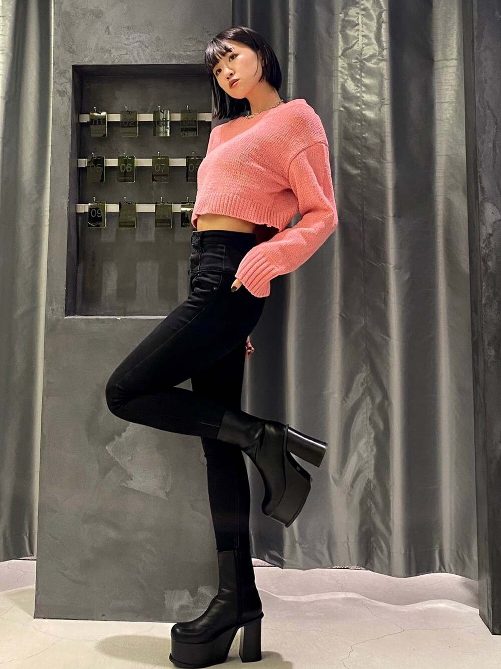 ブラック系のブーツ、ブラック系のデニムパンツ、ピンク系のニット/セーターを着用したレディースの秋コーディネートの3枚目の写真
