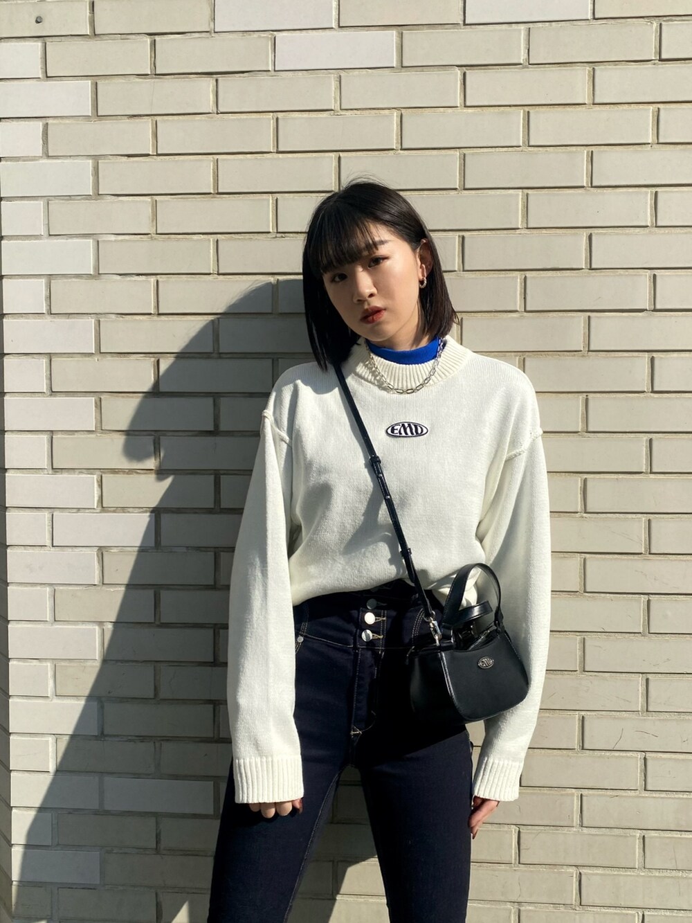 ブラック系のブーツ、ブラック系のハンドバッグ、グレー系のブルゾンを着用したレディースの冬コーディネートの8枚目の写真