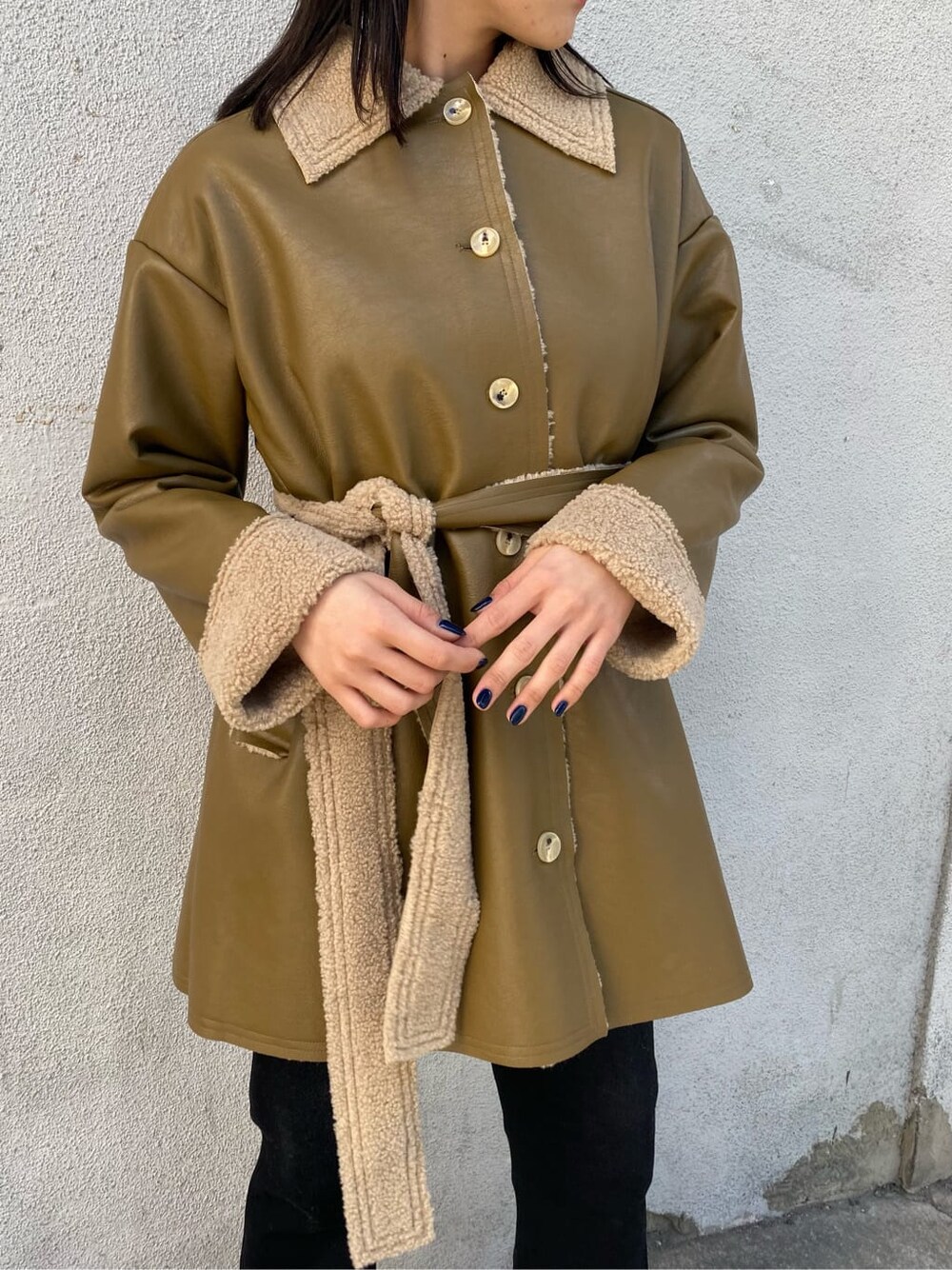 ホワイト系のニット/セーター、ホワイト系のハンドバッグ、ベージュ系のムートンコートを着用したレディースの冬コーディネートの5枚目の写真