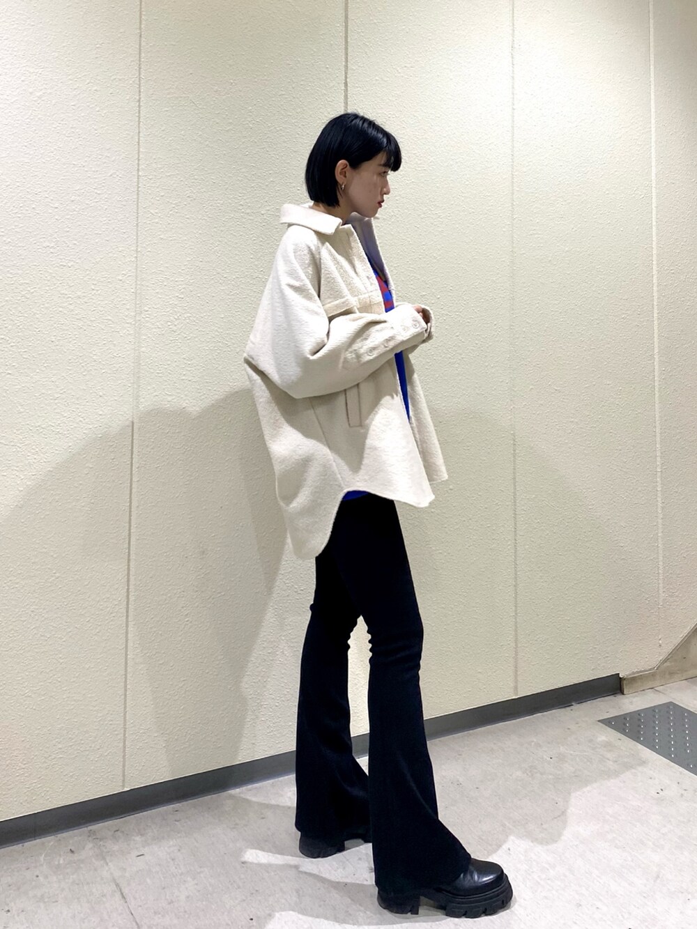 ホワイト系のブルゾン、ブラック系のその他パンツ、ブラック系のブーツを着用したレディースの冬コーディネートの2枚目の写真