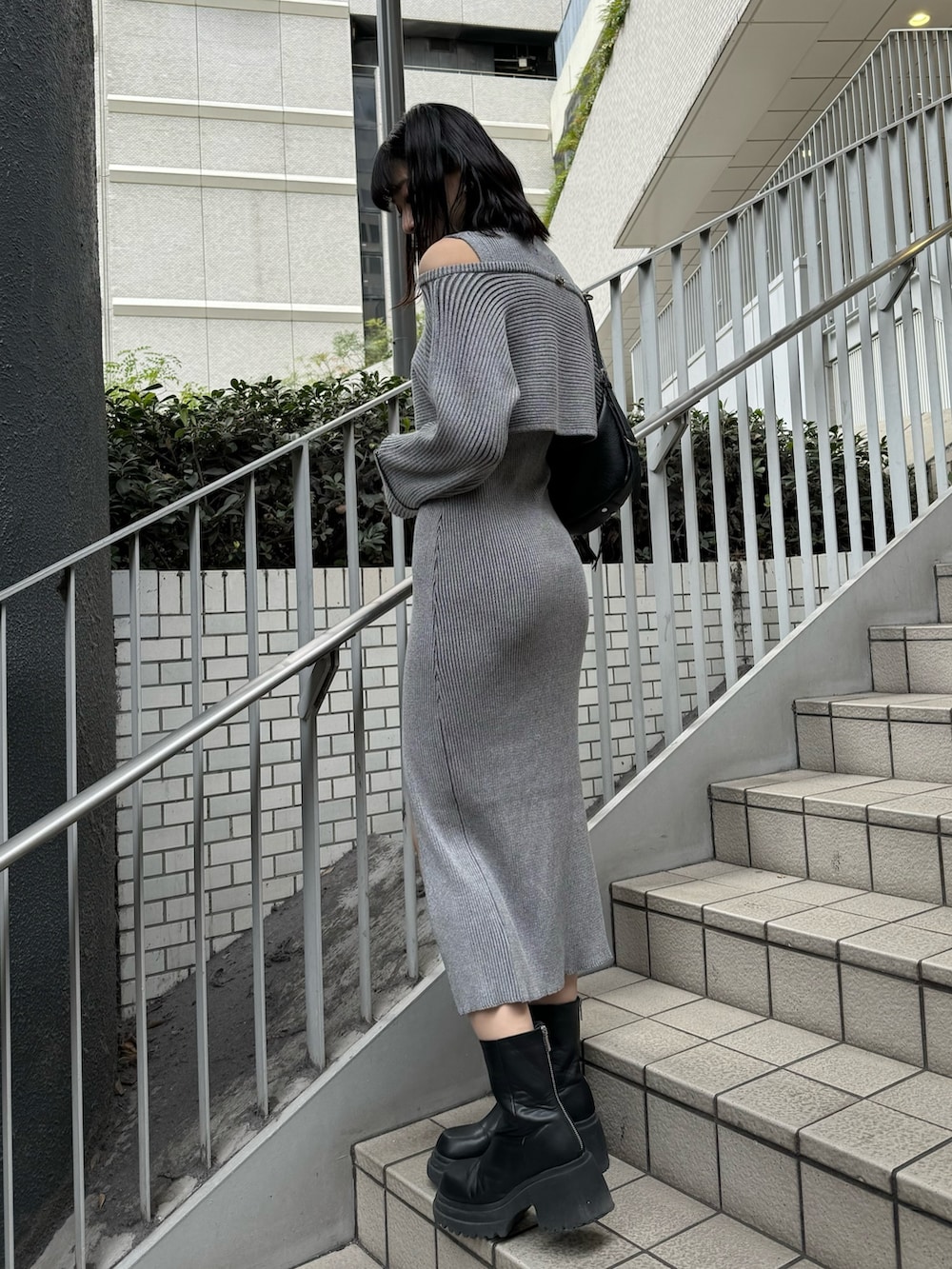 ブラック系のブーツ、グレー系のワンピース、グレー系のエコバッグ/サブバッグを着用したレディースの冬コーディネートの4枚目の写真