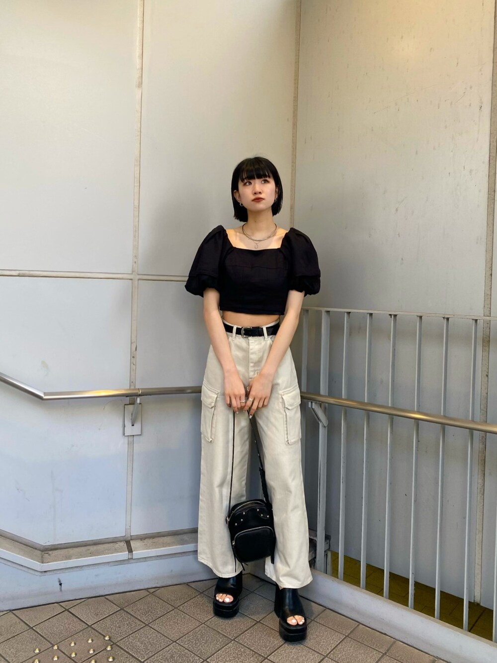 ブラック系のサンダル、ホワイト系のデニムパンツ、ブラック系のシャツ/ブラウスを着用したレディースの春コーディネートの4枚目の写真