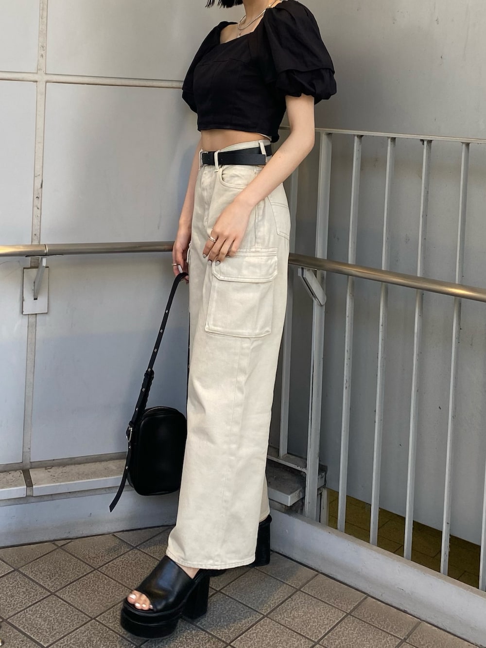 ブラック系のサンダル、ホワイト系のデニムパンツ、ブラック系のシャツ/ブラウスを着用したレディースの春コーディネートの6枚目の写真