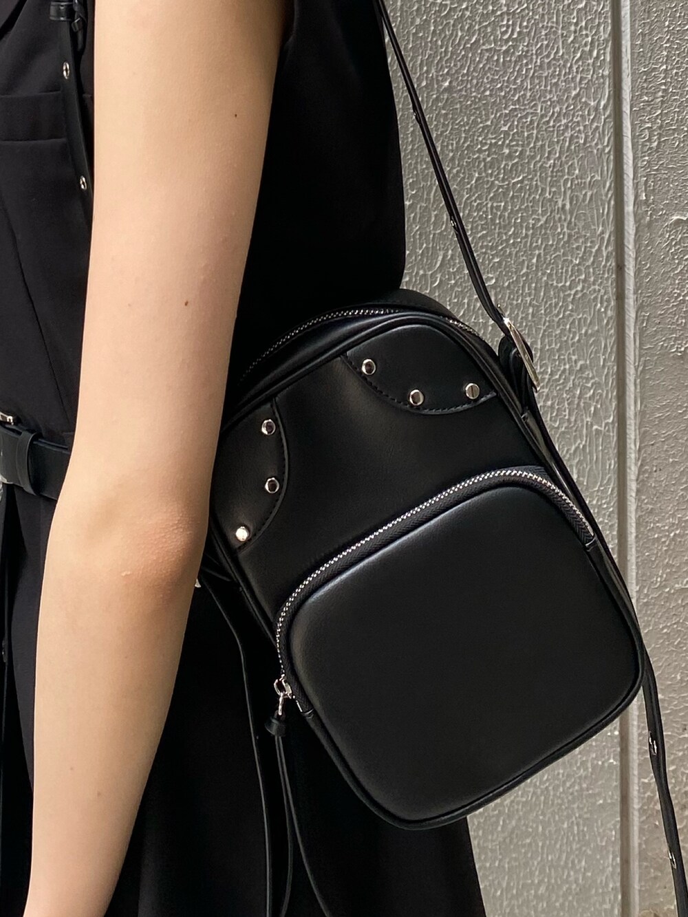 ブラック系のワンピース、ブラック系のサンダル、ブルー系のデニムパンツを着用したレディースの夏コーディネートの9枚目の写真