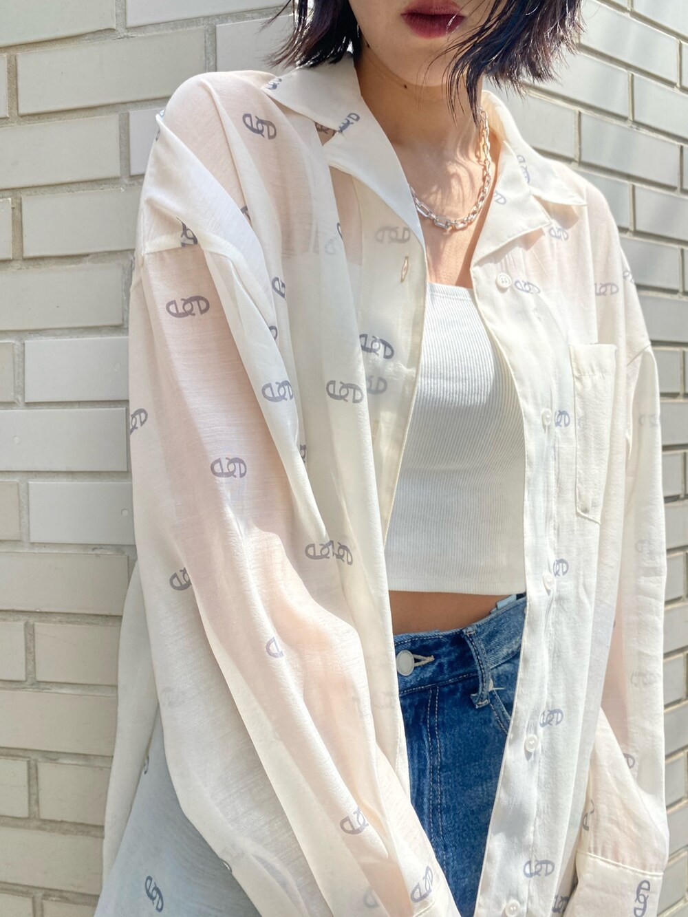 ブラック系のサンダル、ブラック系のハンドバッグ、ブルー系のデニムパンツを着用したレディースの春コーディネートの8枚目の写真