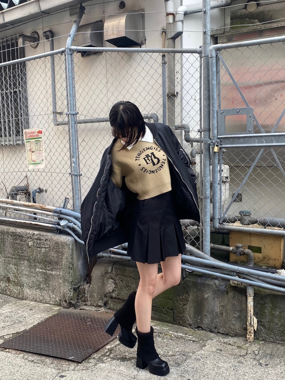 ブラック系のスカート、ブラック系のMA-1、ブラック系のブーツを着用したレディースの秋コーディネートの5枚目の写真