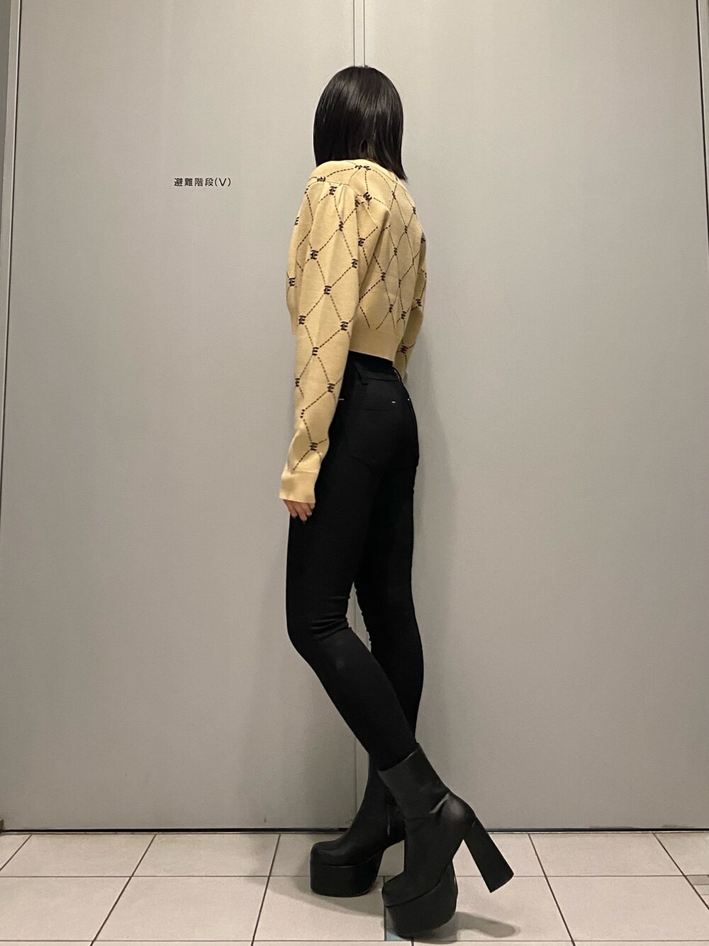 ブラック系のブーツ、ブラック系のデニムパンツ、ベージュ系のニット/セーターを着用したレディースの秋コーディネートの3枚目の写真