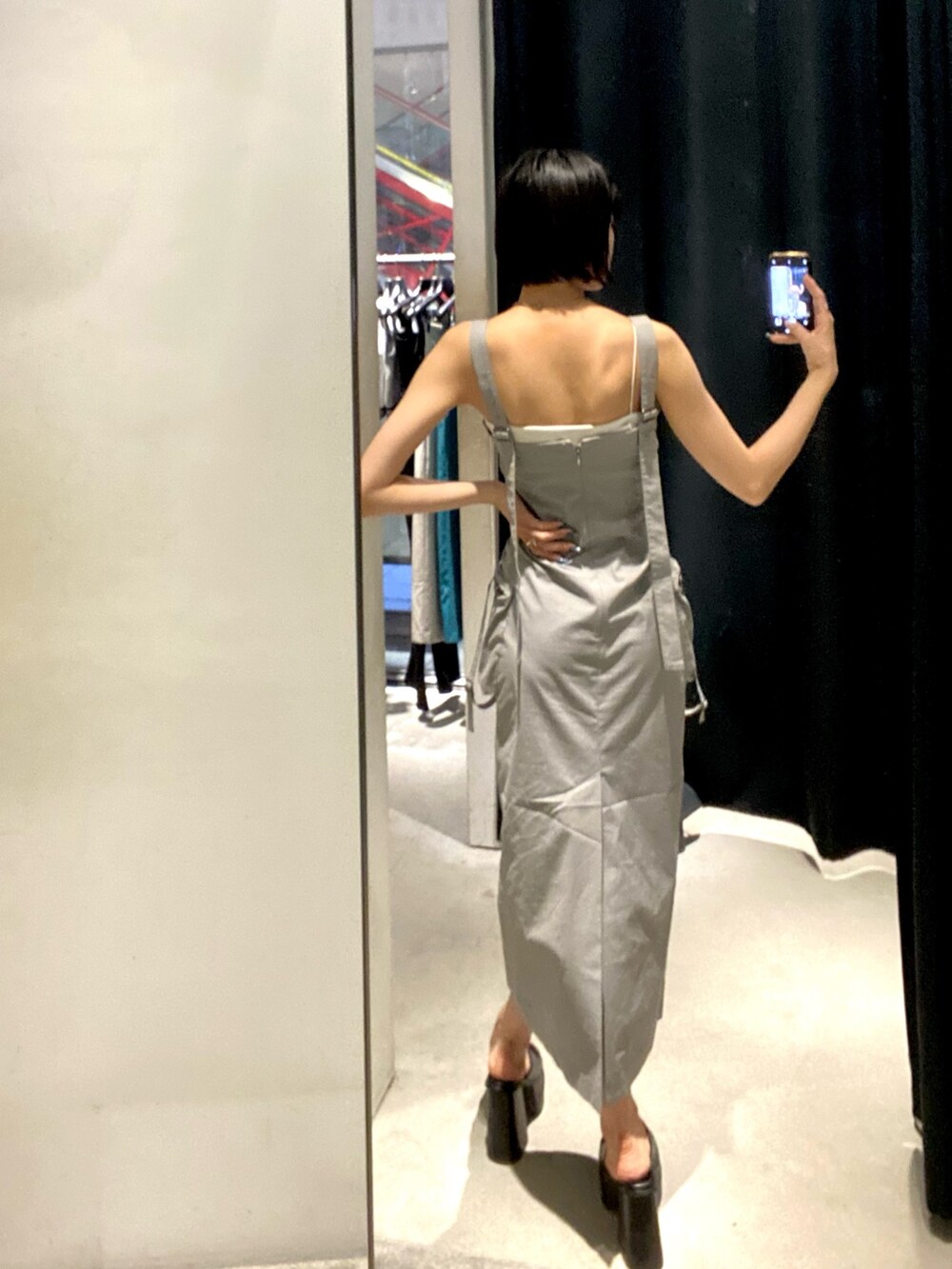 グレー系のワンピース、ブラック系のサンダル、ホワイト系のキャミソールを着用したレディースの夏コーディネートの5枚目の写真