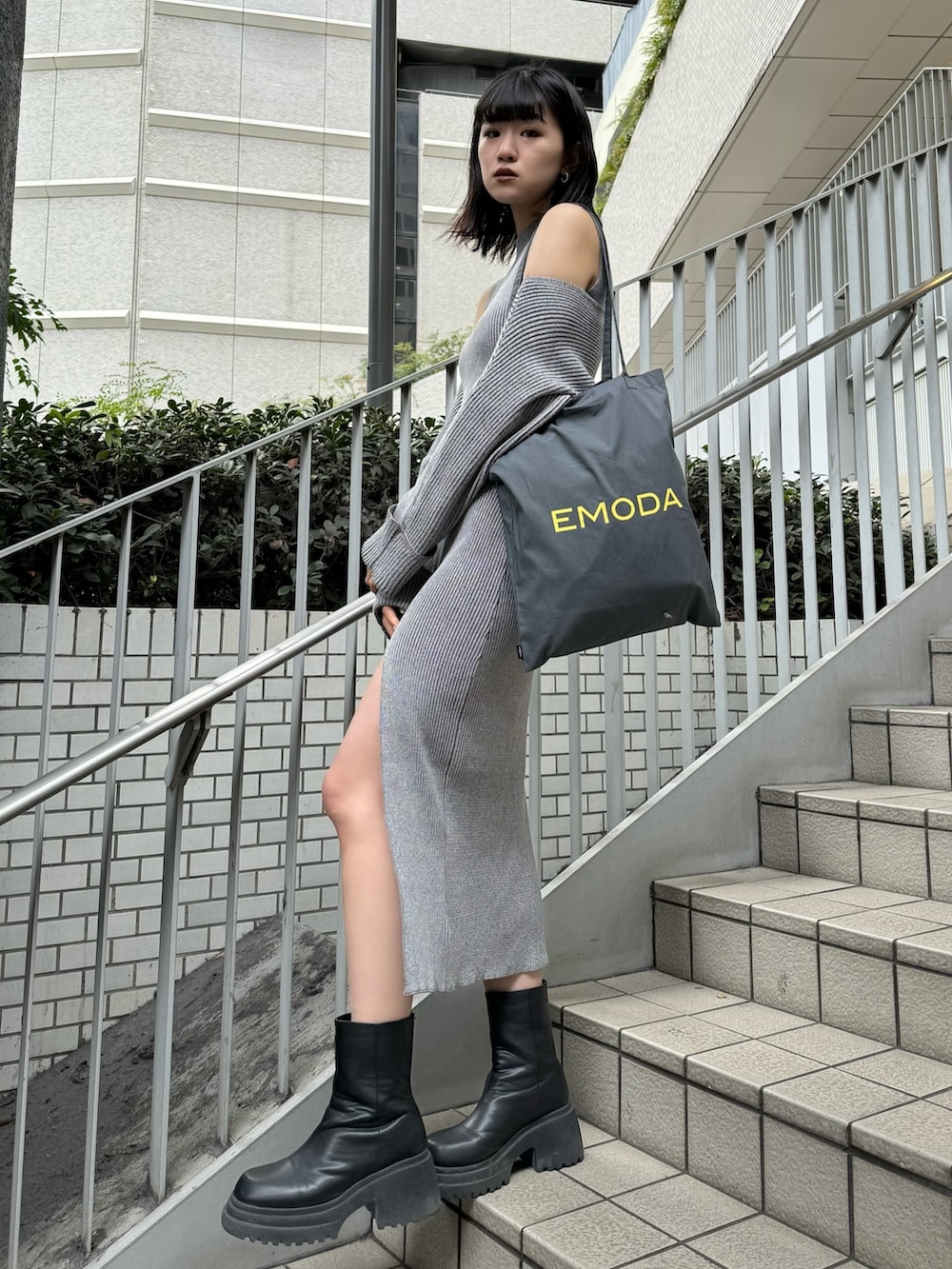 ブラック系のブーツ、グレー系のワンピース、グレー系のエコバッグ/サブバッグを着用したレディースの冬コーディネートの2枚目の写真