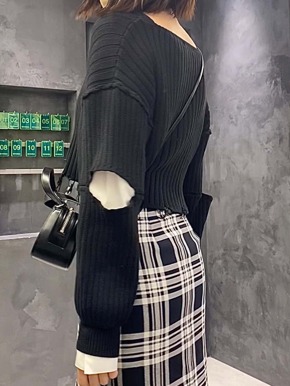 ブラック系のブーツ、その他のスカート、ブラック系のニット/セーターを着用したレディースの冬コーディネートの8枚目の写真