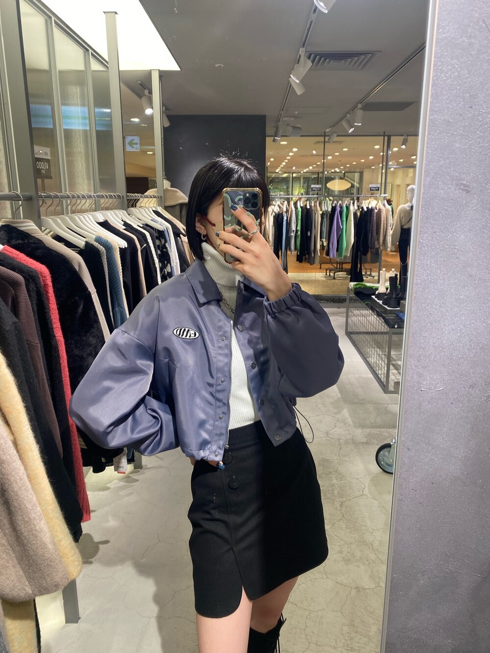 ブラック系のスカート、ブラック系のブーツ、グレー系のブルゾンを着用したレディースの冬コーディネートの5枚目の写真