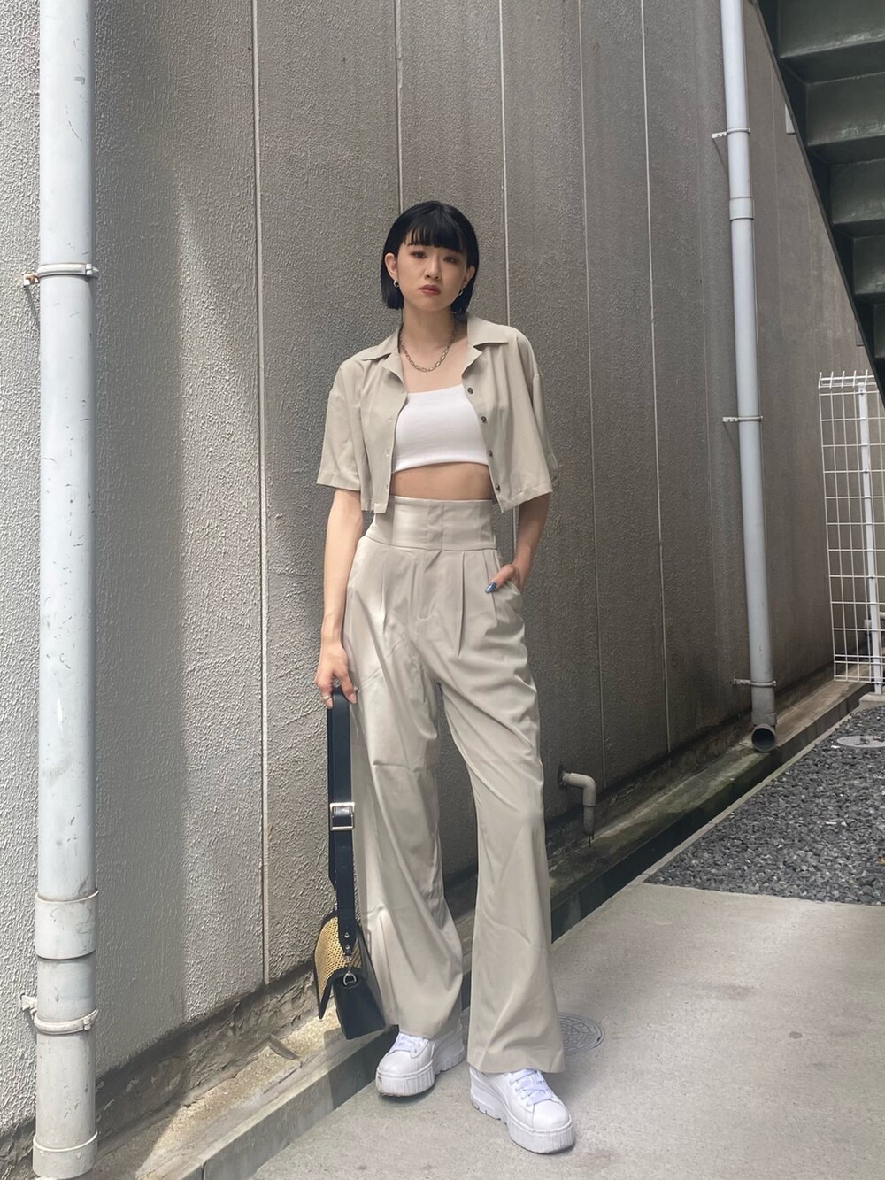 ベージュ系のその他パンツ、ホワイト系のキャミソール、ベージュ系のショルダーバッグを着用したレディースの夏コーディネートの3枚目の写真