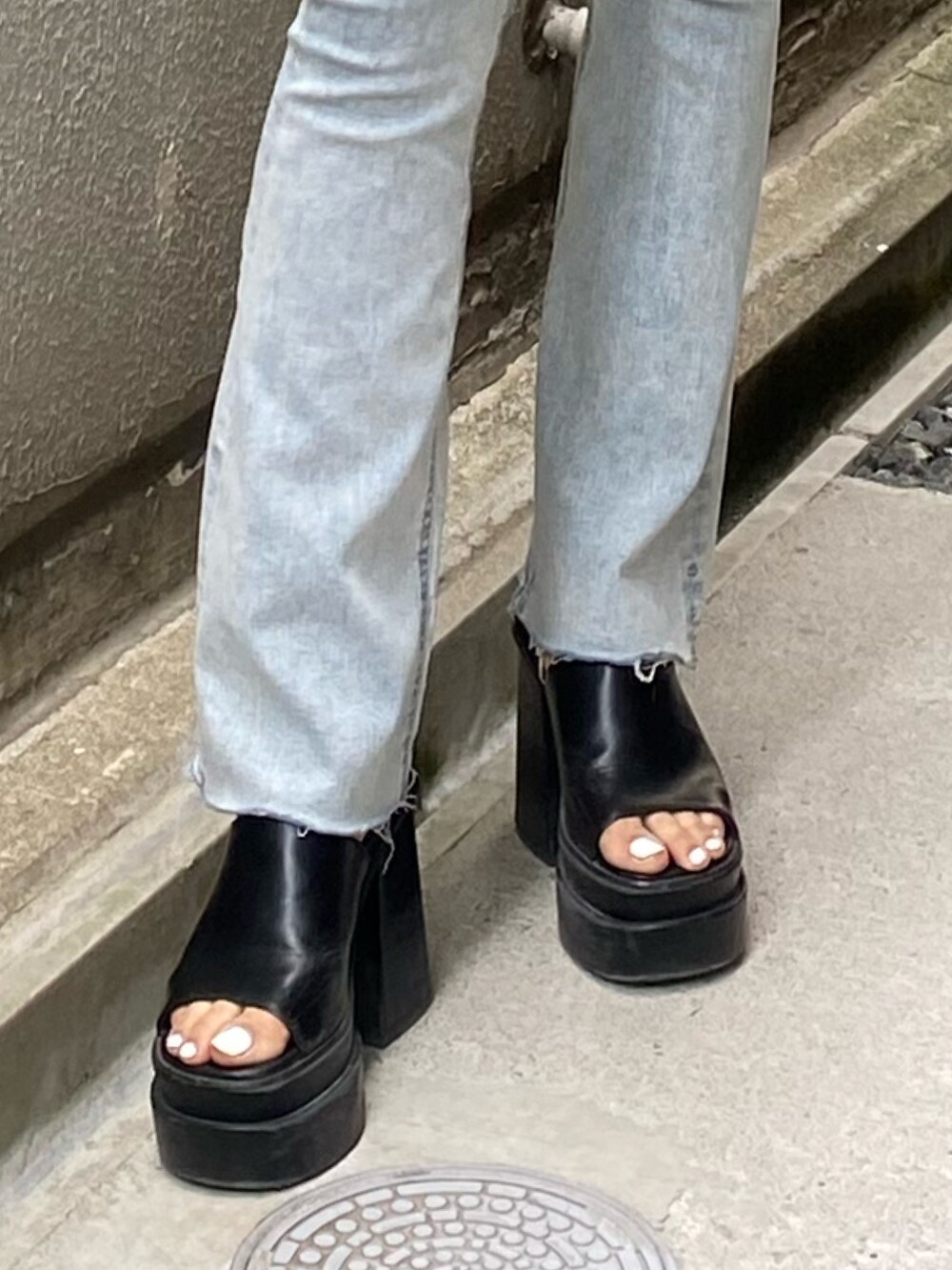 ブラック系のワンピース、ブラック系のサンダル、ブルー系のデニムパンツを着用したレディースの夏コーディネートの8枚目の写真