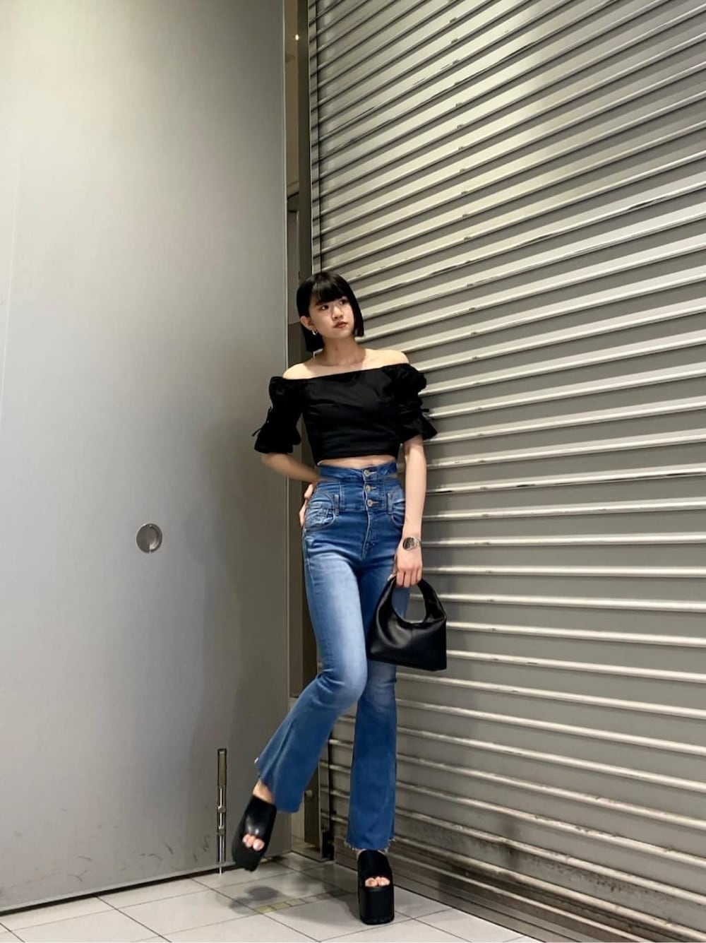 ブルー系のデニムパンツ、ブラック系のサンダル、ブラック系のシャツ/ブラウスを着用したレディースの夏コーディネートの7枚目の写真