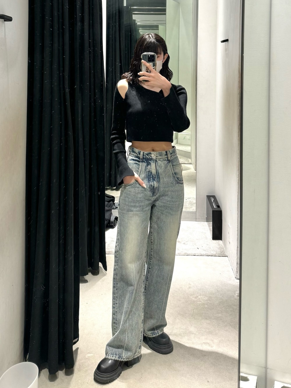 ブラック系のブーツ、ブルー系のデニムパンツ、ブラック系のニット/セーターを着用したレディースの冬コーディネートの2枚目の写真