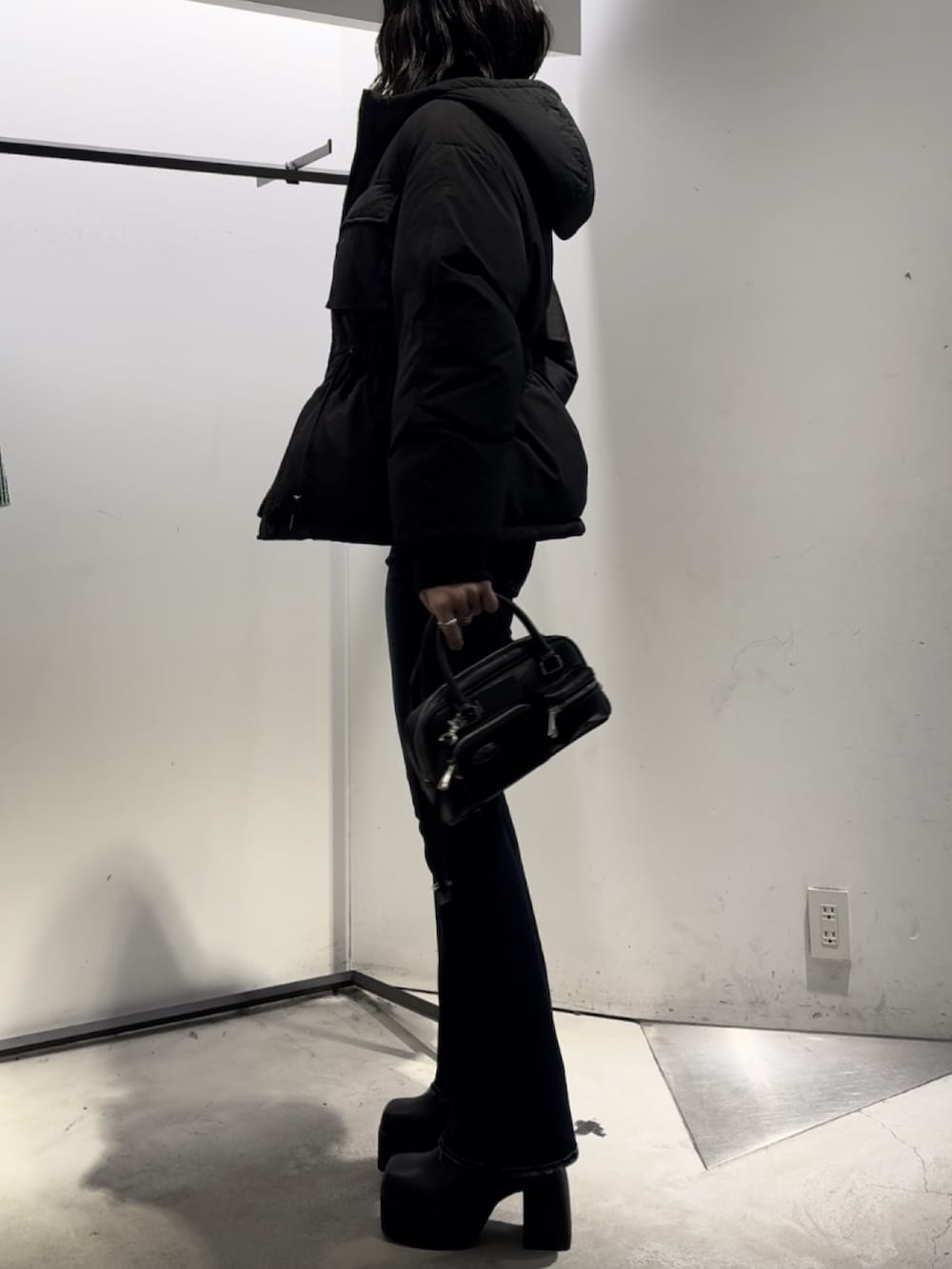 ブラック系のハンドバッグ、ブラック系のニット/セーター、ブルー系のデニムパンツを着用したレディースの冬コーディネートの3枚目の写真