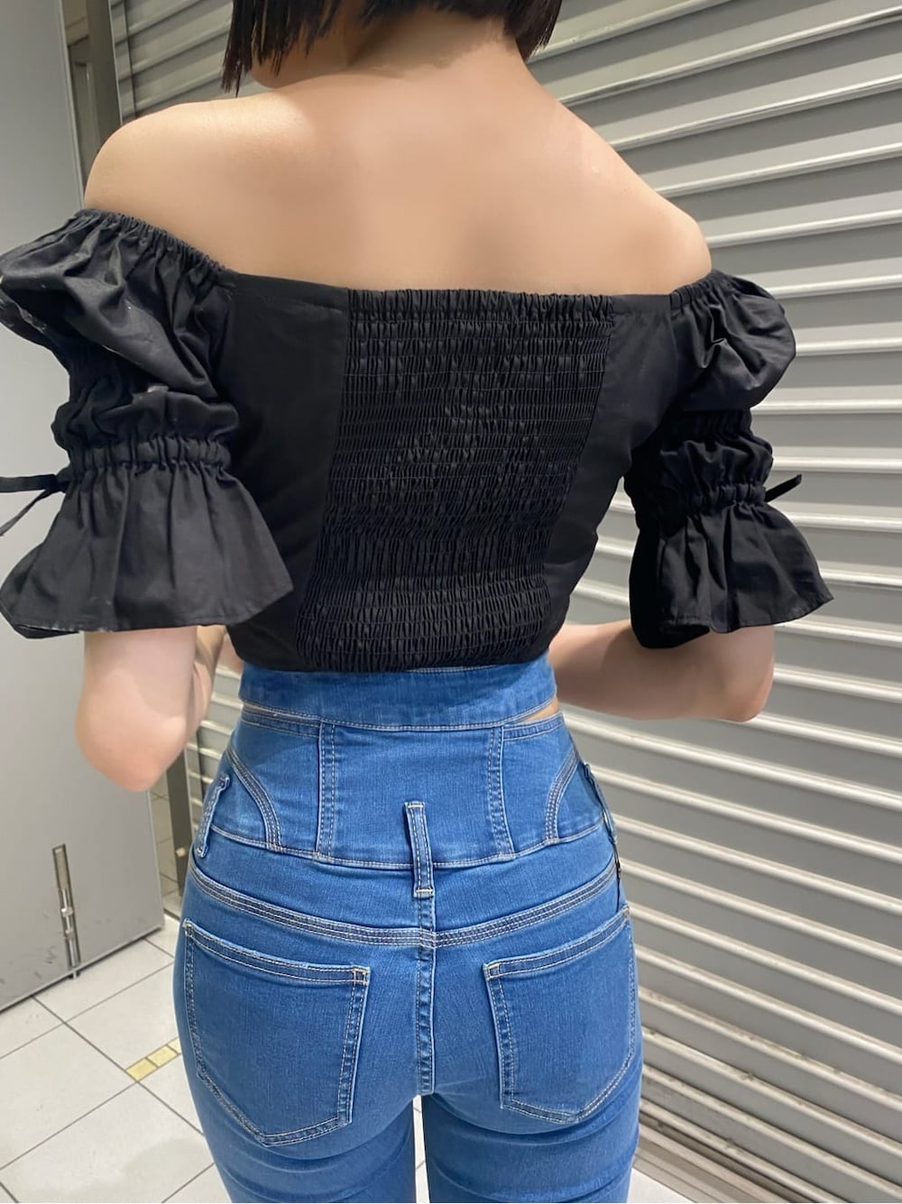 ブルー系のデニムパンツ、ブラック系のサンダル、ブラック系のシャツ/ブラウスを着用したレディースの夏コーディネートの4枚目の写真