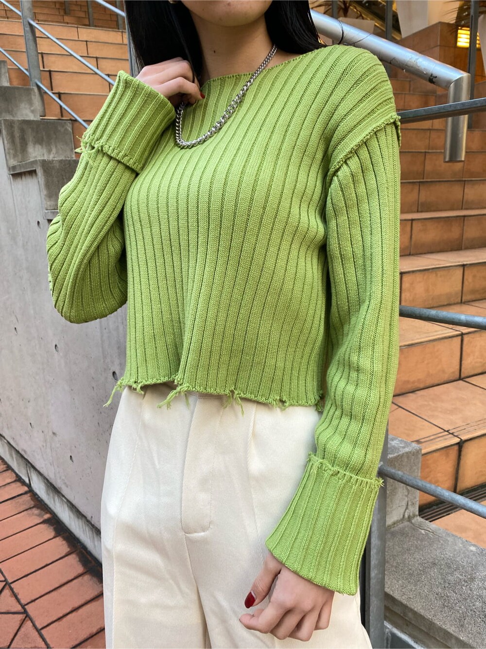 ブラック系のブーツ、ホワイト系のその他パンツ、イエロー系のニット/セーターを着用したレディースの冬コーディネートの6枚目の写真